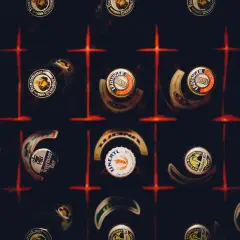 Kapsle piwne różnych marek, w tym Erdinger i Franziskaner, tworzą mozaikę. Każda kapsla to mały patron piwa, opowiadający historię smaku.