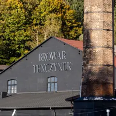 Browar Tenczynek, z charakterystycznym kominem i jesiennymi drzewami w tle. Właściciel dba o tradycję.