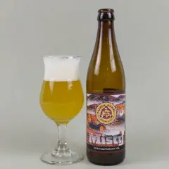 Szklanka z bursztynowym piwem i pianką obok butelki "Misty" Contemporary IPA. Idealny new england ipa na wieczór.