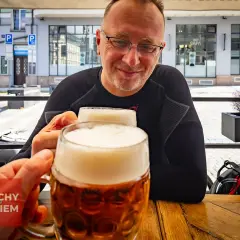 Dwóch mężczyzn wznosi toast pysznym czeskim piwem w słoneczny dzień.
