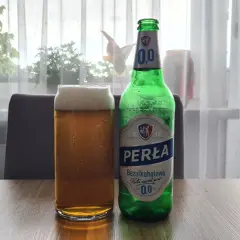Szklanka i butelka Perły Bezalkoholowej. Perła wśród piw, 0,0% alkoholu, idealna na orzeźwienie.