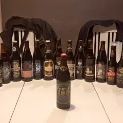 Stół zastawiony butelkami i puszkami piwa, idealny na dzień porteru bałtyckiego. Widać różne marki i etykiety.