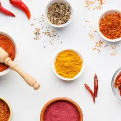 Miseczki z przyprawami: papryka, kurkuma, szafran, chili. Ile procent ostrości w tej warkocze czerwonej?