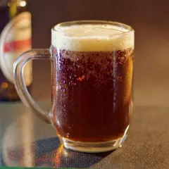 Chłodne piwo w kuflu, z kroplami rosy na szkle. Obok butelka. Zastanawiasz się, czy piwo zamarza?