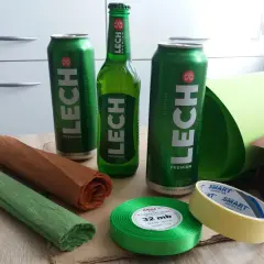 Jak zrobić prezent z piwa? Potrzebne będą puszki i butelka piwa Lech, ozdobny papier, wstążka i taśma.