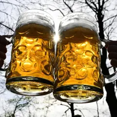 Dwa kufle piwa, złociste i orzeźwiające, unoszą się w blasku słońca. Czy to mocne piwo, jak Tatry?