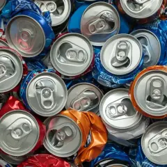 Stos zgniecionych puszek po piwie, głównie niebieskich i srebrnych. Zastanawiasz się, ile waży puszka po piwie?