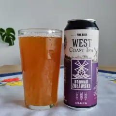 Szklanka piwa West Coast IPA obok puszki Browaru Żuławski. Na obrusie haftowane kwiaty.