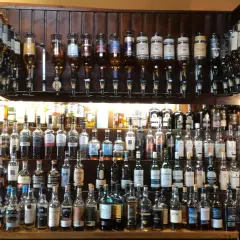 Wielka półka pełna butelek szkockiego piwa i whisky, gotowych do degustacji.