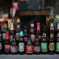 Rząd butelek piwa, w tym piwo z pomorza, z etykietami w różnych językach i stylach.