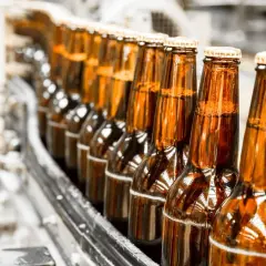 Szklane butelki piwa na linii produkcyjnej AB InBev.