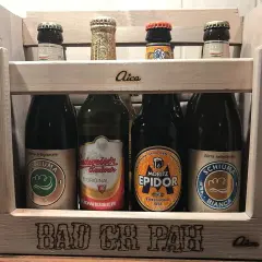 Drewniana skrzynka z butelkami piwa, w tym piwo klasyczne polskie. Na skrzynce napis "BAD CH PAH".