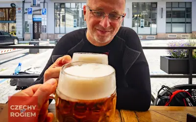 Dwóch mężczyzn wznosi toast pysznym czeskim piwem w słoneczny dzień.