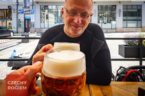 Dwóch mężczyzn wznosi toast pysznym czeskim piwem w słoneczny dzień.