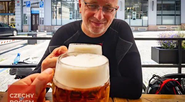 Dwóch mężczyzn wznosi toast pysznym czeskim piwem w słoneczny dzień.