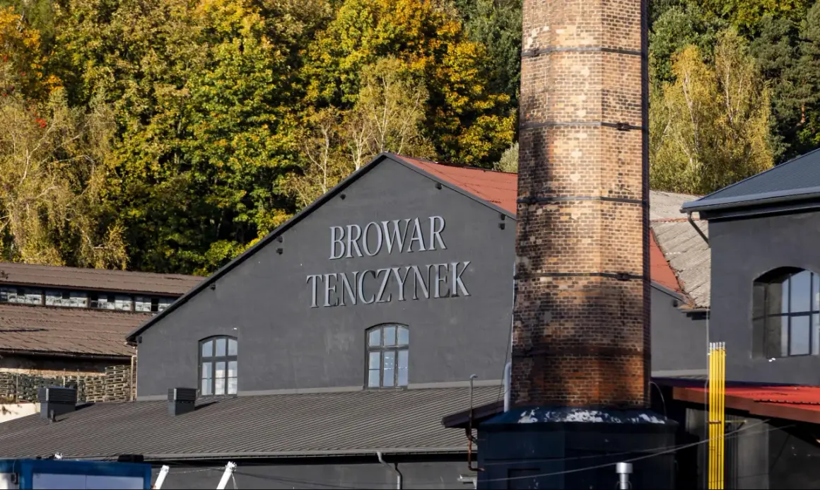 Browar Tenczynek, z charakterystycznym kominem i jesiennymi drzewami w tle. Właściciel dba o tradycję.
