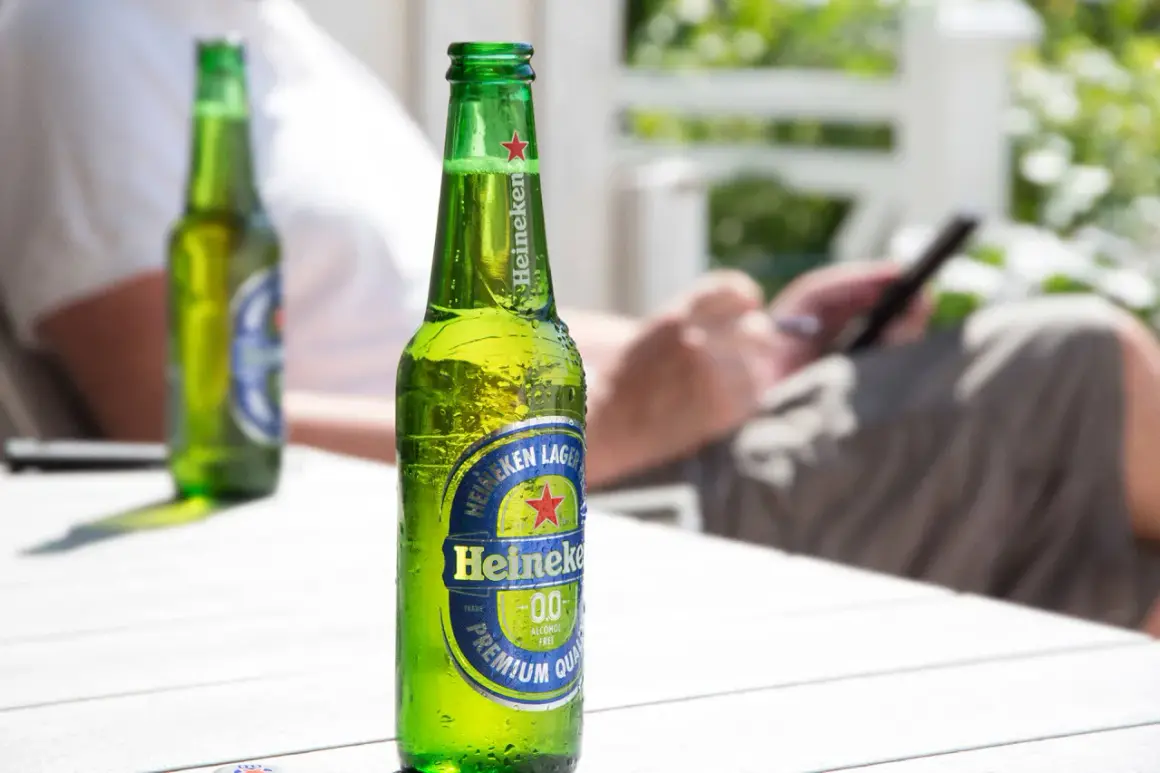 Chłodna butelka Heineken 0.0% na stole. Idealna na upalny dzień, gdy zastanawiasz się, heineken ile procent ma ten napój.