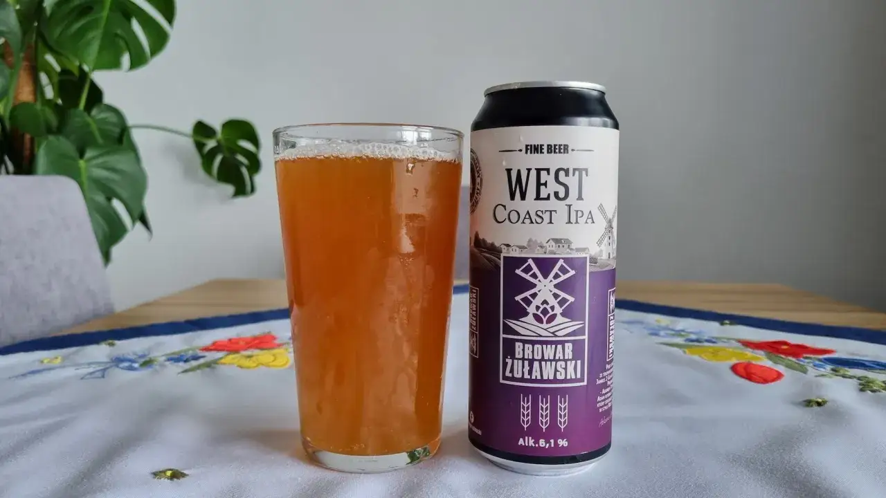 Szklanka piwa West Coast IPA od Browaru Żuławski obok puszki.