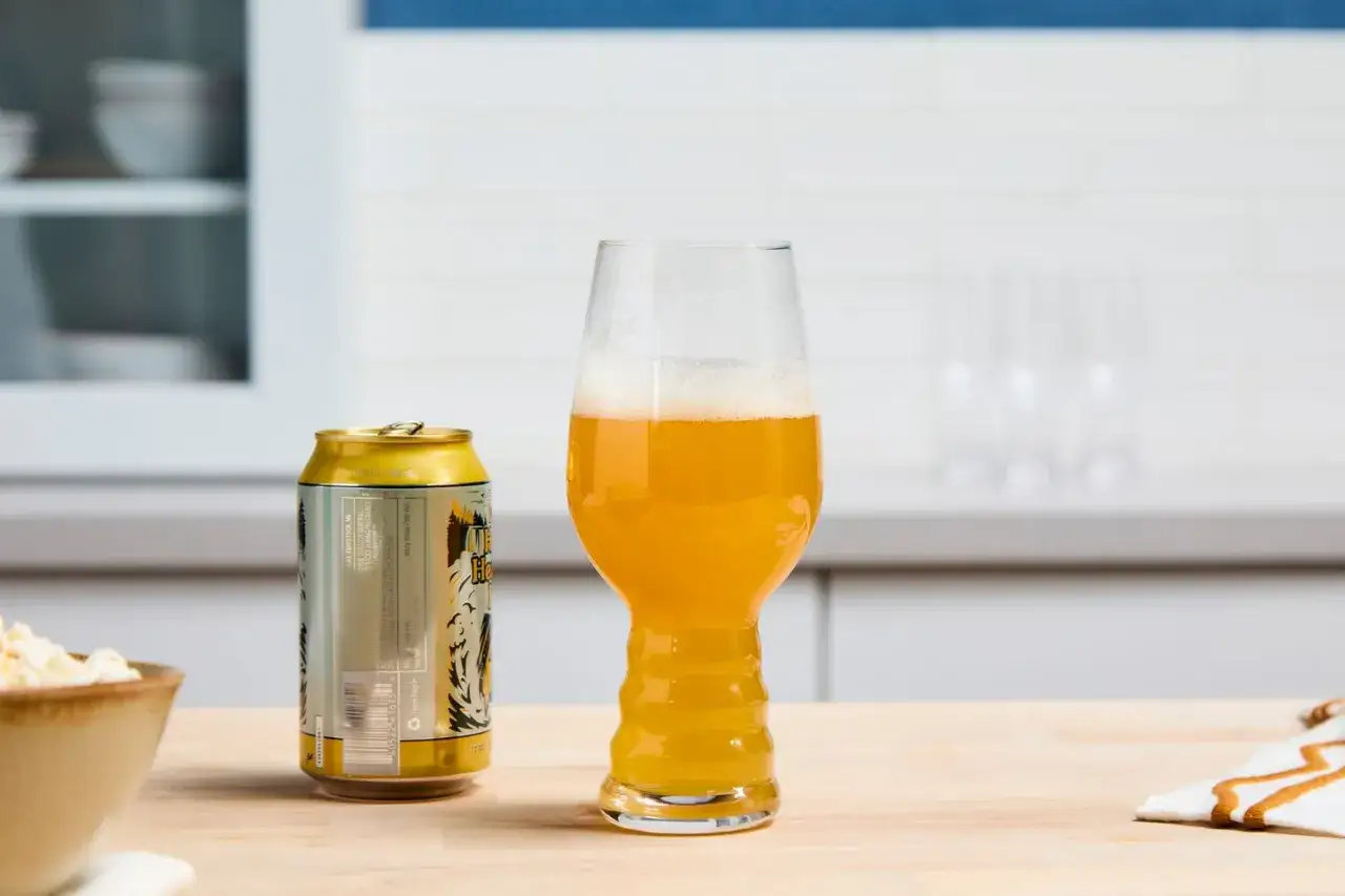 Złota puszka piwa IPA i pełny kielich tego orzeźwiającego napoju, gotowe do degustacji.