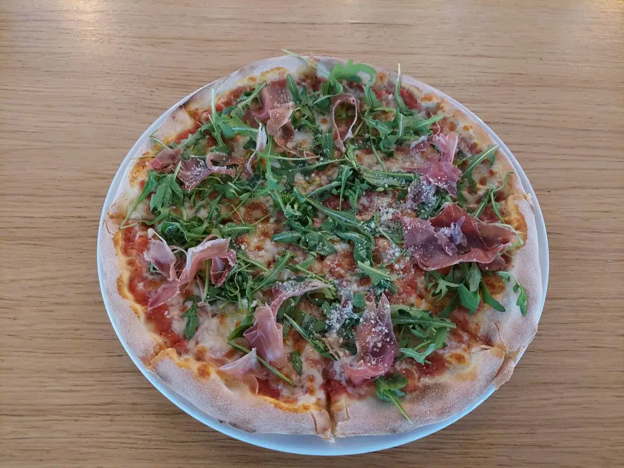 Pizza z rukolą i szynką parmeńską, idealna na relaks w qufel beer park.