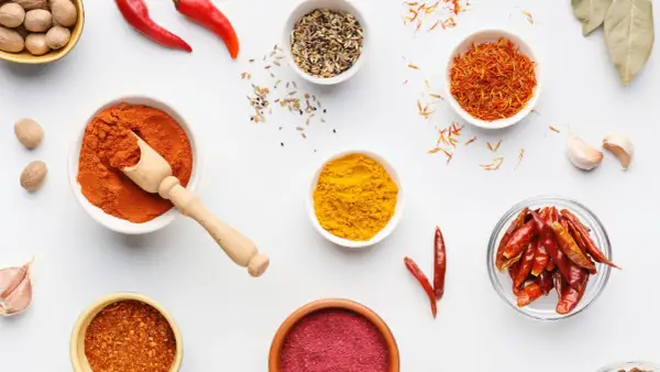 Miseczki z przyprawami: papryka, kurkuma, szafran, chili. Ile procent ostrości w tej warkocze czerwonej?