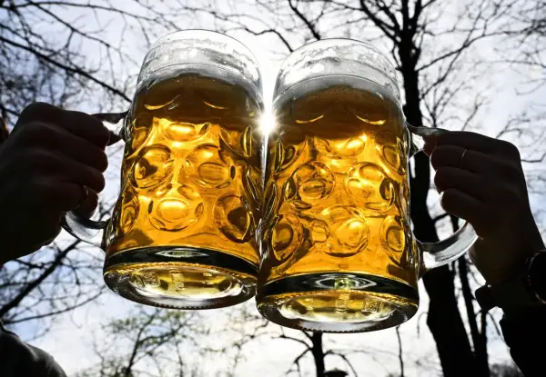 Dwa kufle piwa, złociste i orzeźwiające, unoszą się w blasku słońca. Czy to mocne piwo, jak Tatry?