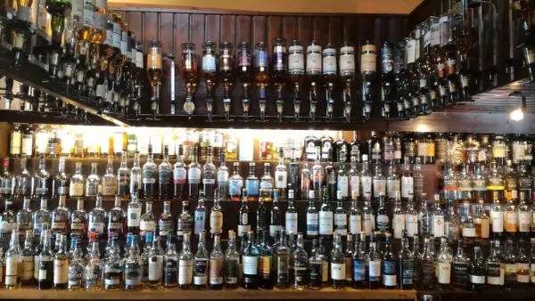 Wielka półka pełna butelek szkockiego piwa i whisky, gotowych do degustacji.