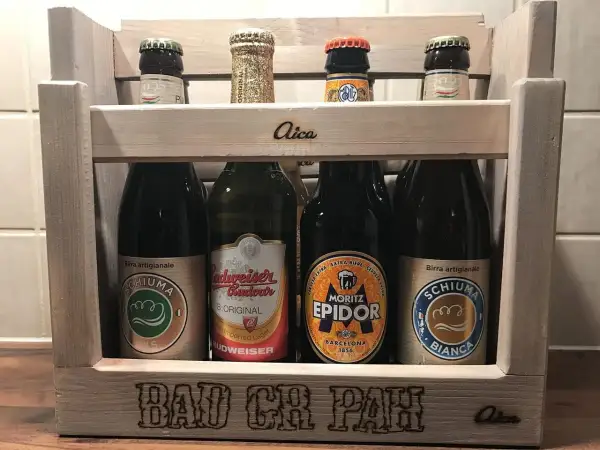 Drewniana skrzynka z butelkami piwa, w tym piwo klasyczne polskie. Na skrzynce napis "BAD CH PAH".
