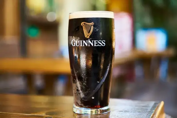 Szklanka Guinnessa z pianką. Czy wiesz, że garbniki co to są, nadają piwu charakterystyczny smak i kolor?